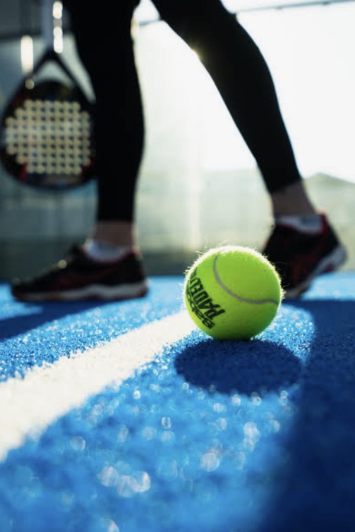 Padel racket on a blue court surface with padel balls in Southern Nevada